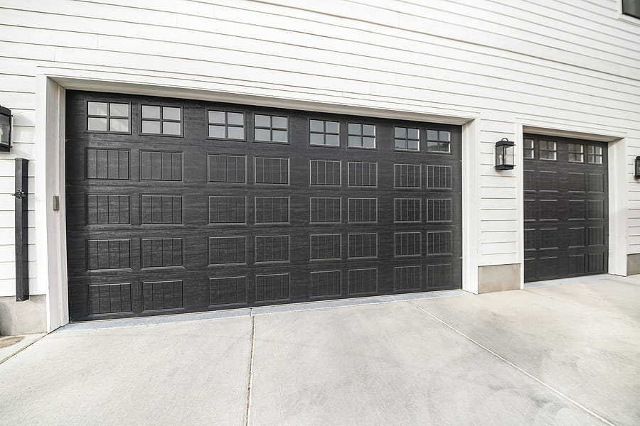 Two Black Garage Doors With Window Panels And Wall Lighting A modern black garage door in Chicago