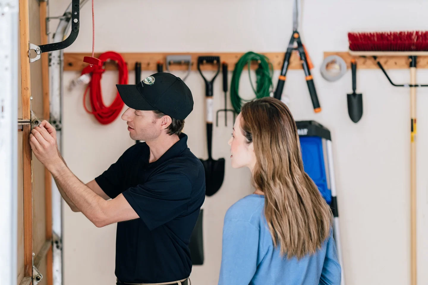 Precision technician inspecting a garage door (1) Precision Garage Door technician inspecting garage door with customer