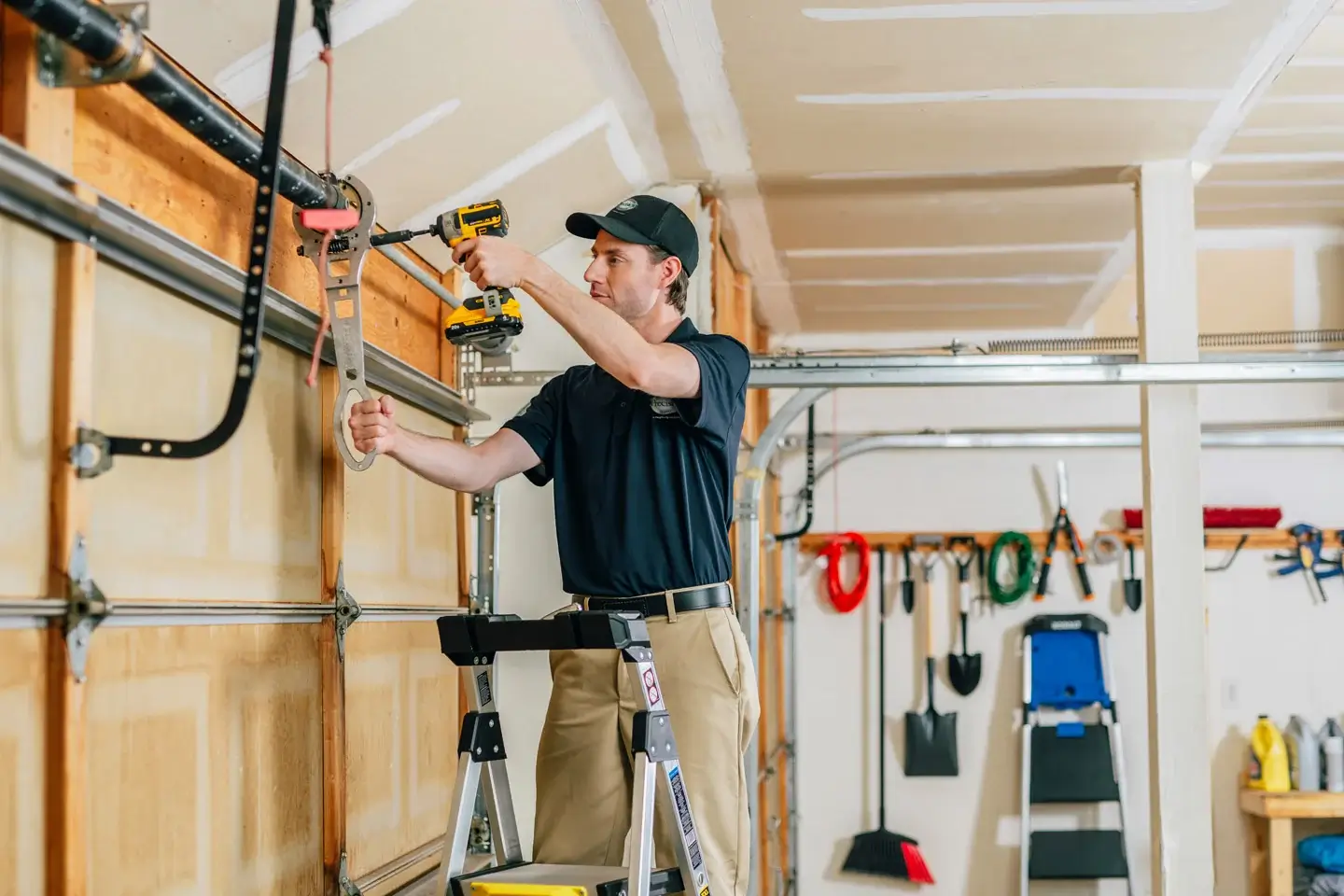 Precision Garage Door technician repairing garage door rollers and springs.