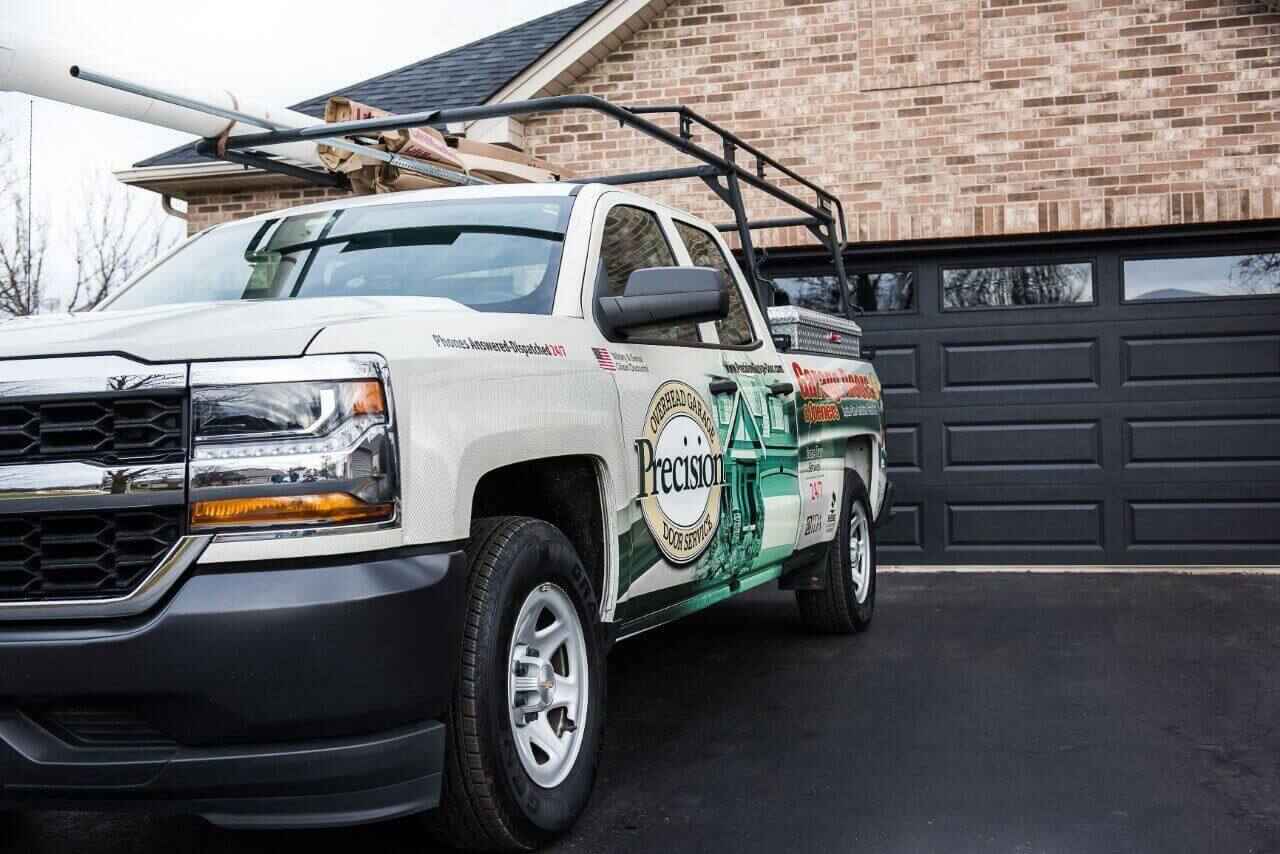 Precision Garage Door Service truck with tools and equipment, servicing a home garage.