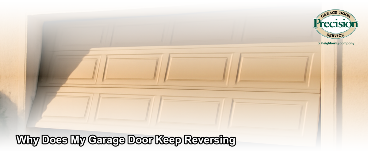 A residential garage door partially open in mid-reverse, with safety sensor lights visible near the base of the door tracks in a California home